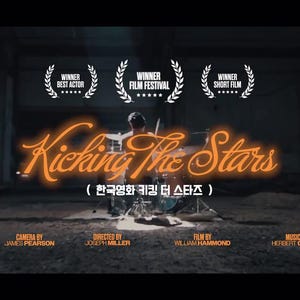 May include: A movie poster for "Kicking The Stars" featuring a drummer playing a drum set. The title is in orange neon script. The poster includes the text "Winner Best Actor", "Winner Film Festival", and "Winner Short Film".