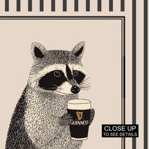 Op de afbeelding: Zwart-wit illustratie van een wasbeer met een pint Guinness. De wasbeer heeft een zwart masker en staat tegen een beige achtergrond. Het Guinness-glas heeft een gouden harp logo.