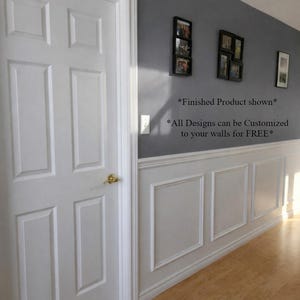 May include: A white six-panel door with a gold doorknob is on the left. The wall is painted grey with white trim and decorative panels. The text on the wall reads, "Finished Product shown" and "All Designs can be Customized to your walls for FREE*"