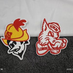 May include: Two embroidered patches. One features a cartoon character in a yellow hat with a red feather. The other is a red and white wolf head with the text "UNM" and "LOBOS".