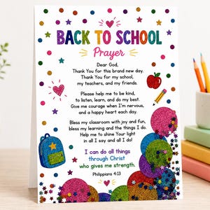 May include: A white card featuring the text BACK TO SCHOOL Prayer in colourful glittery letters. The design includes a red apple, a yellow pencil, a blue backpack, and various colourful glittery circles and stars surrounding the prayer text.