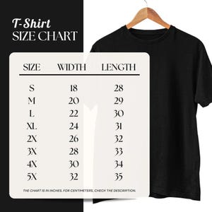 May include: A black t-shirt hanging on a wooden hanger. A size chart for t-shirts is on the left, with sizes from S to 5X. The chart shows width and length measurements in inches, from 18 to 32 inches wide and 28 to 35 inches long. Check description for cm.