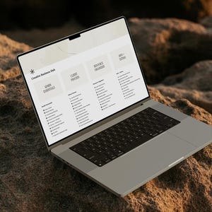 K&ouml;nnte beinhalten: Ein silberner Laptop, der eine Creative Business Hub-Oberfl&auml;che auf dem Bildschirm anzeigt. Der Bildschirm zeigt vier Hauptspalten mit den Titeln Admin Essentials, Client Process, Resource Organizer und Info + Extras mit Aufgabenlisten.