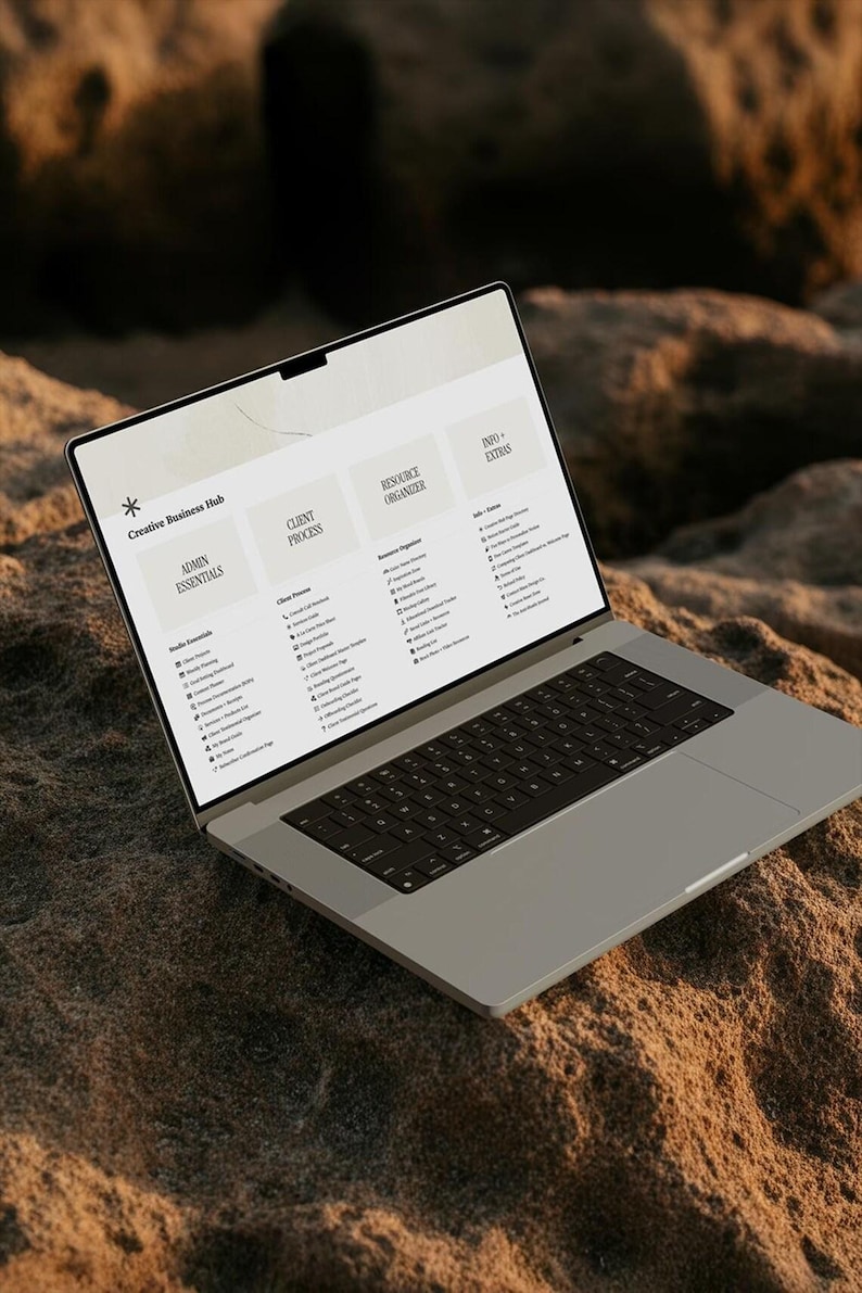 K&ouml;nnte beinhalten: Ein silberner Laptop, der eine Creative Business Hub-Oberfl&auml;che auf dem Bildschirm anzeigt. Der Bildschirm zeigt vier Hauptspalten mit den Titeln Admin Essentials, Client Process, Resource Organizer und Info + Extras mit Aufgabenlisten.