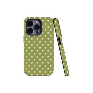 May include: A green phone case with a pattern of small, evenly spaced pink polka dots. The case is shown with a matching side piece, both against a white background. The case has a camera cutout.