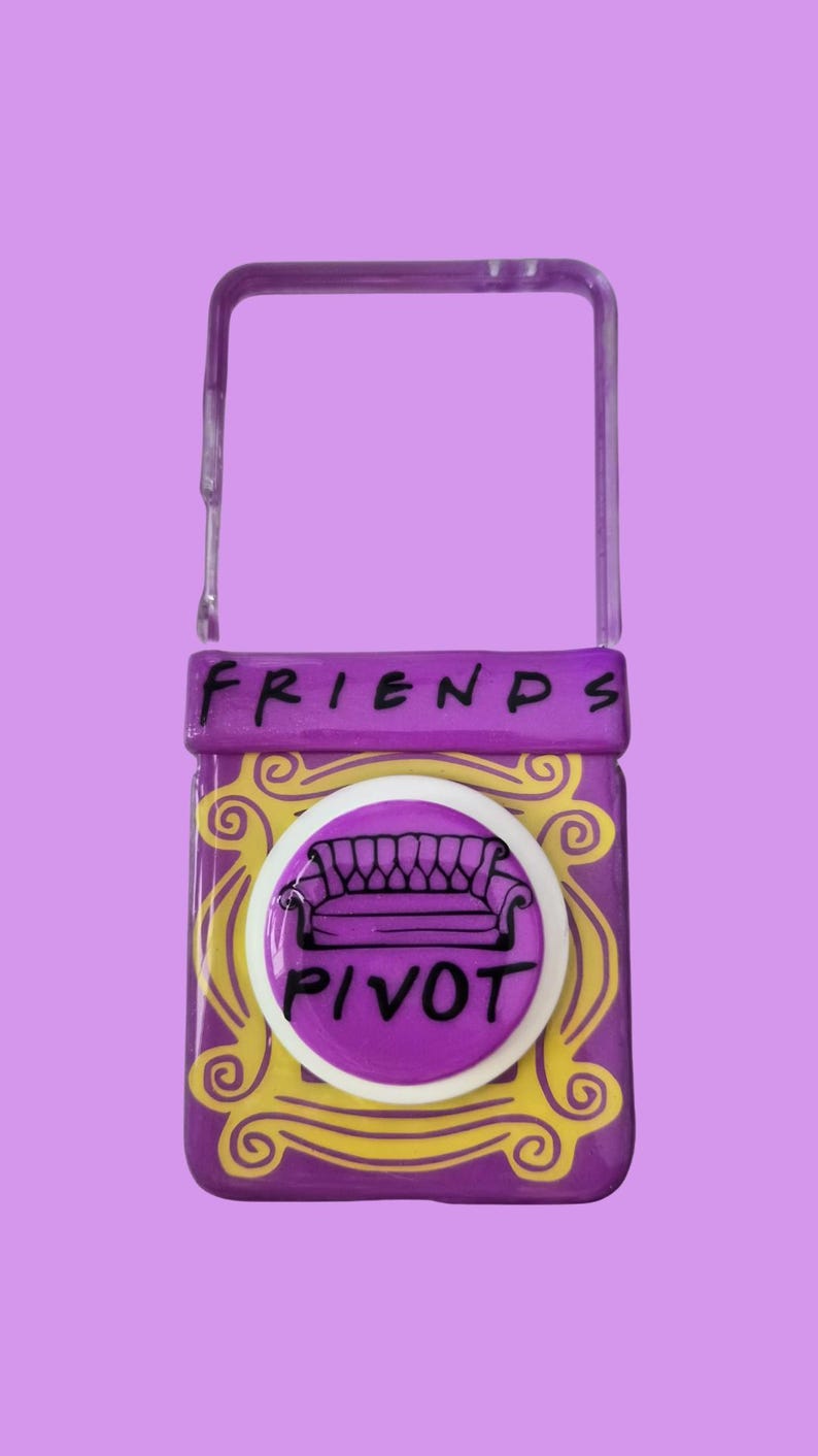 Pu&ograve; includere: Una cover per telefono rettangolare viola con un design a cornice decorativa gialla. La parola FRIENDS &egrave; stampata in nero nella parte superiore. &Egrave; presente un supporto circolare bianco, che mostra un disegno a linee nere di un divano e la parola PIVOT.