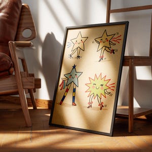 May include: A framed art print featuring four cartoon stars with smiling faces and dancing poses. The stars are in various colors, including yellow, blue, and a light brown background. The artwork is displayed on a wooden floor.