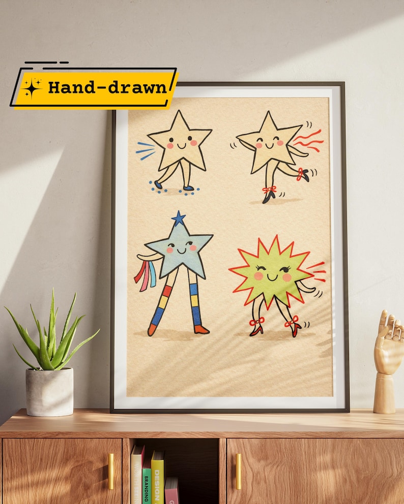 May include: A framed art print featuring four whimsical star characters with smiling faces and various outfits. The stars are hand-drawn and set against a beige background. The text "Hand-drawn" is in a yellow banner in the upper left corner.