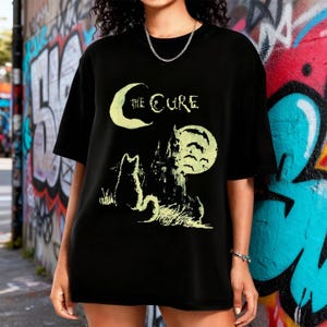 May include: A white ceramic mug with a black handle and the text "But First, Coffee" in a black, bold font. The mug is on a white surface. The mug is approximately 10 cm tall.