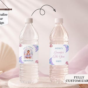 May include: Two clear plastic water bottles with custom labels featuring a mermaid theme. The labels display the text Our Lil Mermaid, Aniyah's Oneder The Sea Party, and a photograph of a child. The design includes purple mermaid tails.