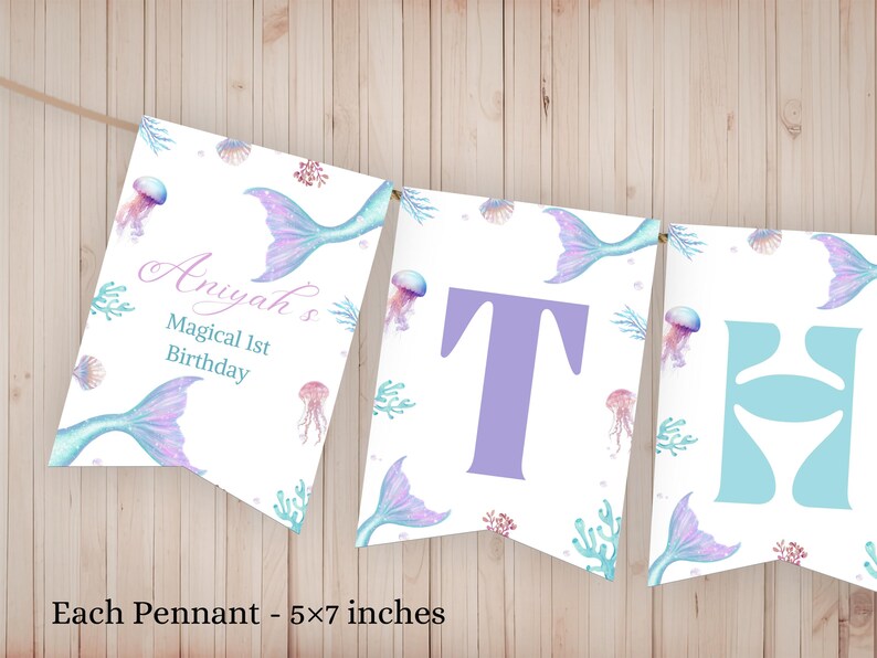 K&ouml;nnte beinhalten: Ein dekoratives Banner mit drei wei&szlig;en Wimpeln, die jeweils 12,7x17,8 cm gro&szlig; sind. Das Design zeigt Aquarellillustrationen von Meerjungfrauenschw&auml;nzen, Quallen und Korallen. Der erste Wimpel tr&auml;gt den Text Aniyah's Magical 1st Birthday.