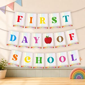 Può includere: Uno striscione decorativo con tre file di bandierine bianche a righe verticali colorate a forma di matita. Le lettere compongono FIRST DAY OF SCHOOL con caratteri multicolori e una mela rossa sostituisce la lettera O in DAY.