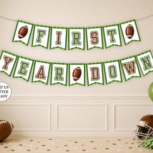 Puede incluir: Una guirnalda decorativa de dos niveles con banderines blancos de bordes verdes y letras de bloque en marrón y verde que forman la frase FIRST YEAR DOWN. La guirnalda incluye ilustraciones de balones de fútbol americano y una etiqueta circular A4 & US LETTER READY.