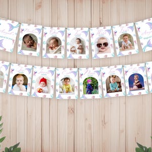 Pu&ograve; includere: Uno striscione fotografico per tappe mensili composto da tredici cartoncini rettangolari appesi a uno spago. Ogni cartoncino mostra la foto di un bambino, un'etichetta del mese da neonato a dodici e un bordo a tema sirena con meduse e code viola.