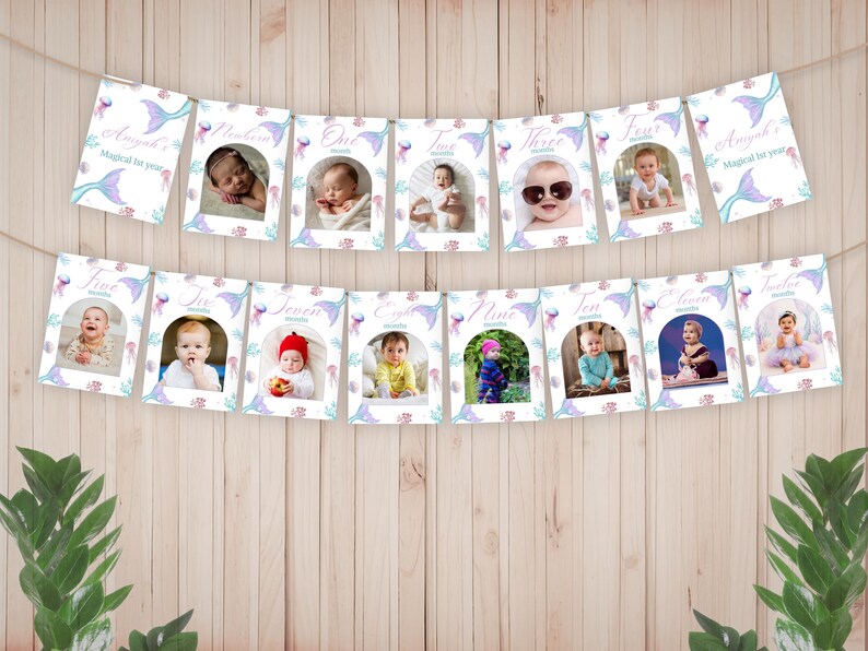 Pu&ograve; includere: Uno striscione fotografico per tappe mensili composto da tredici cartoncini rettangolari appesi a uno spago. Ogni cartoncino mostra la foto di un bambino, un'etichetta del mese da neonato a dodici e un bordo a tema sirena con meduse e code viola.