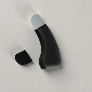 May include: A black and grey beauty tool with a curved handle and a detached cap. The tool has a grey tip and a sleek, modern design. The detached cap is black and has a rounded shape.