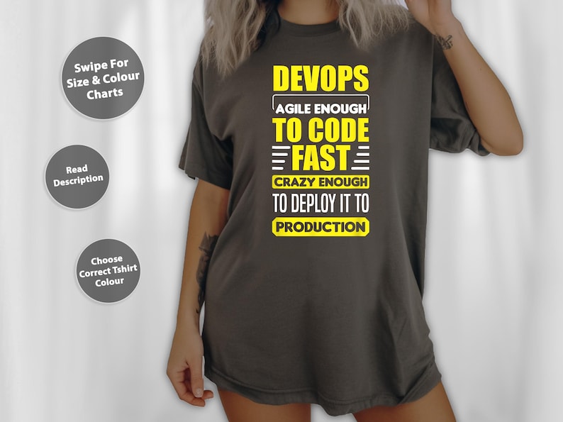 以下が含まれることがあります： 「DEVOPS AGILE ENOUGH TO CODE FAST CRAZY ENOUGH TO DEPLOY IT TO PRODUCTION」と書かれた黄色の文字が入った濃い灰色のTシャツ。シャツには、テキストが入った3つの灰色の丸いボタンもあります。
