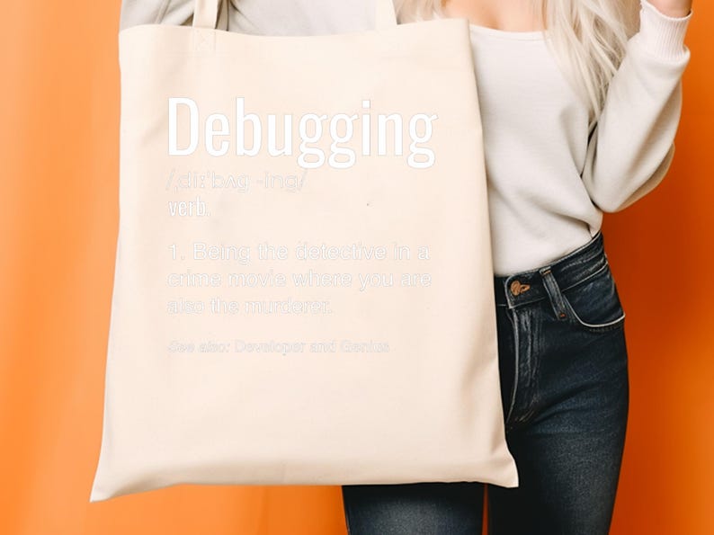 Może przedstawiać: Beżowa torba z białym napisem "Debugging" i definicją. Torba jest trzymana przez osobę w białym swetrze i niebieskich dżinsach na pomarańczowym tle.