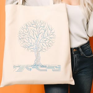 K&ouml;nnte beinhalten: Cremefarbene Tragetasche mit einem stilisierten Baumdesign aus hellblauem Text. Der Baum hat ein Leiterplattenmuster am Boden. Die Tasche wird vor einem orangefarbenen Hintergrund gehalten.