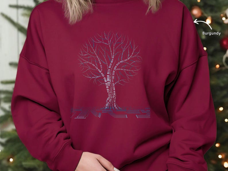 K&ouml;nnte beinhalten: Burgunderfarbenes Sweatshirt mit einem Baumdesign aus Bin&auml;rcode und dem Wort "CODE". Die &Auml;ste des Baumes werden durch die Bin&auml;rziffern 0 und 1 gebildet. Das Sweatshirt ist ein lang&auml;rmeliger Rundhalsausschnitt.