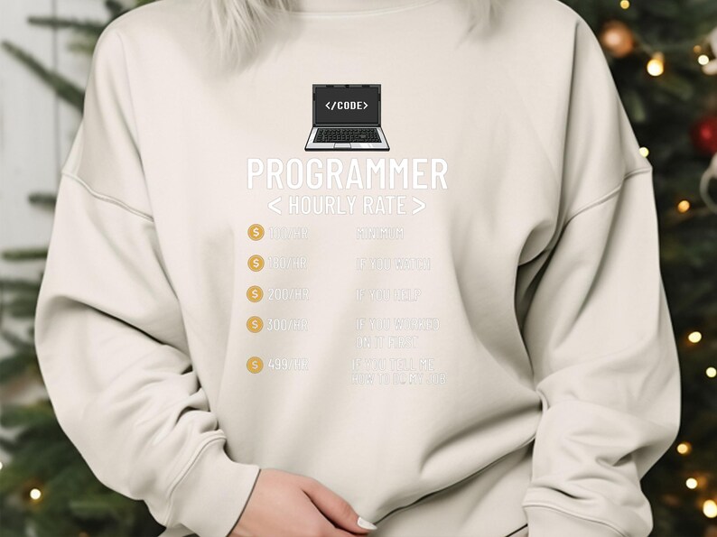 May include: Cream-coloured sweatshirt featuring the word "PROGRAMMER" in white, a laptop graphic, and hourly rate details. The design incorporates gold pound signs. A casual garment for tech professionals.