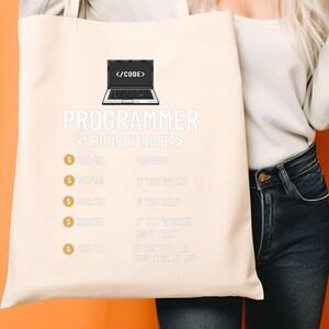 May include: A cream tote bag with the word "PROGRAMMER" in white. The bag has a laptop graphic and text about hourly rates. The text includes phrases like "If you need" and "If you tell me".