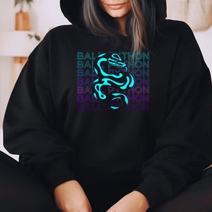 K&ouml;nnte beinhalten: Schwarzer Kapuzenpullover mit einer neonblauen und violetten Schlange und dem Text "BALL PYTHON" vertikal gestapelt. Das Design ist mittig auf der Vorderseite des Kleidungsst&uuml;cks platziert.
