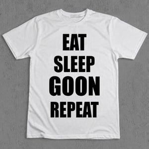Könnte beinhalten: Ein weißes T-Shirt mit kurzen Ärmeln und fettgedrucktem schwarzem Text, der mittig auf der Brust platziert ist. Der Text ist in vier Zeilen angeordnet und lautet EAT, SLEEP, GOON, REPEAT in einer einfachen serifenlosen Schriftart.