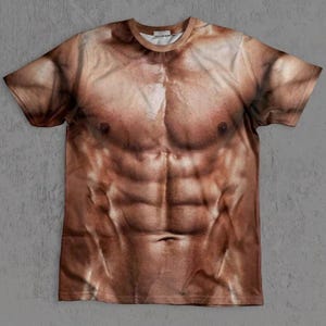 Könnte beinhalten: Ein kurzärmeliges T-Shirt mit Rundhalsausschnitt und einem realistischen, hochauflösenden Fotodruck eines muskulösen menschlichen Oberkörpers mit definierten Brust- und Bauchmuskeln in verschiedenen Braun- und Hauttönen.