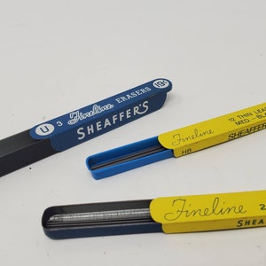 May include: Three vintage Sheaffer's Fineline mechanical pencil lead refills. The blue and black refill box says "U 3 Fineline Erasers 19¢ SHEAFFER'S". The blue and yellow refill box says "Fineline HB 12 Thin Leads Med-Black 25¢ SHEAFFER F15". The yellow and black refill box says "Fineline 2H Thin Leads Hard SHEAFFER'S".