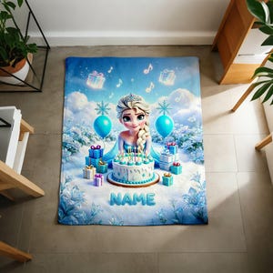 K&ouml;nnte beinhalten: Eine rechteckige Fleecedecke mit einer Zeichentrickfigur mit blondem Zopf, einer Geburtstagstorte mit brennenden Kerzen, blauen Geschenken und Luftballons. Der Hintergrund zeigt eine Schneelandschaft mit blauen Blumen und dem Wort NAME.