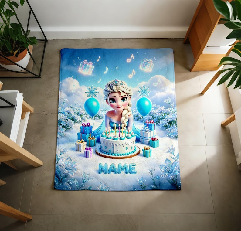 K&ouml;nnte beinhalten: Eine rechteckige Fleecedecke mit einer Zeichentrickfigur mit blondem Zopf, einer Geburtstagstorte mit brennenden Kerzen, blauen Geschenken und Luftballons. Der Hintergrund zeigt eine Schneelandschaft mit blauen Blumen und dem Wort NAME.