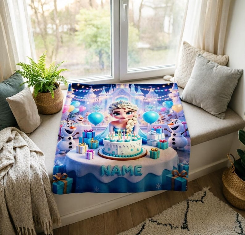 K&ouml;nnte beinhalten: Eine rechteckige Fleecedecke mit einer farbenfrohen Illustration einer blonden Figur mit Zopf, zwei Schneem&auml;nnern und einer Geburtstagstorte auf einem Tisch. Das Wort NAME ist auf die Tischdecke gedruckt, umgeben von Geschenkboxen.