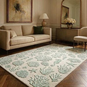 Puede incluir: Una alfombra rectangular con una base de color crema y un patr&oacute;n texturizado en relieve de vida marina en color verde menta claro, que incluye diversas formaciones de coral, estrellas de mar y caballitos de mar distribuidos por toda la superficie.