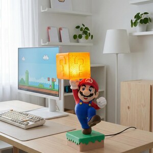 May include: A Mario-themed lamp featuring the iconic character holding a glowing question mark block. The lamp is on a green and brown base, with a power cord. The design is inspired by the popular video game series.