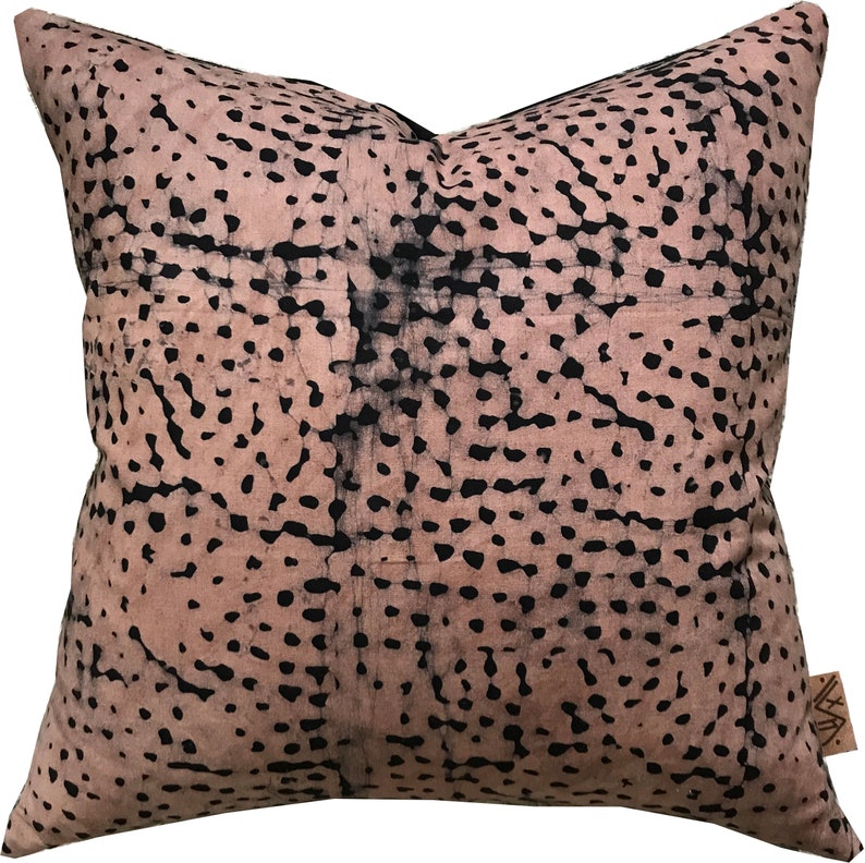May include: A pink and black patterned throw pillow with a subtle batik design. The pillow is made of a soft, comfortable fabric and features a unique, abstract pattern.