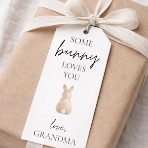May include: A present wrapped in brown paper, secured with a cream ribbon and bow. A white tag features the text "Some bunny loves you" and a watercolour bunny illustration. The tag also reads "love, Grandma."