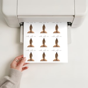 Pu&ograve; includere: Un foglio di adesivi stampati con una figura in una veste che sale una collina, con le parole "walk with me" in un carattere corsivo. Gli adesivi sono stampati su carta bianca e sono tenuti in mano.