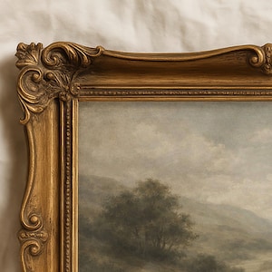 Pode incluir: Uma pintura de paisagem em uma moldura dourada ornamentada. A pintura retrata um c&eacute;u nublado sobre um terreno montanhoso com uma &aacute;rvore em primeiro plano. A moldura tem entalhes detalhados e um tom dourado quente.