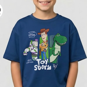 Puede incluir: Una camiseta azul marino con personajes de la pel&iacute;cula de animaci&oacute;n "Toy Story". El dise&ntilde;o incluye a Woody, Buzz Lightyear y Rex el dinosaurio, con las palabras "Toy Story" en una fuente l&uacute;dica. La camiseta la lleva una persona.