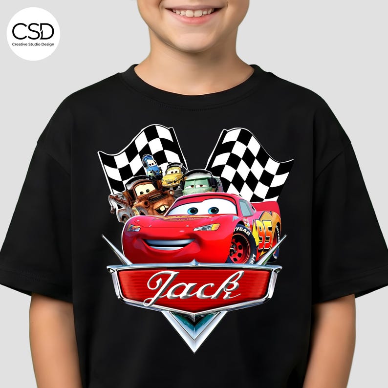 Puede incluir: Camiseta negra con un gr&aacute;fico de Rayo McQueen de la pel&iacute;cula Cars, y el nombre "Jack" en una insignia. El dise&ntilde;o incluye banderas a cuadros y otros personajes de la pel&iacute;cula.