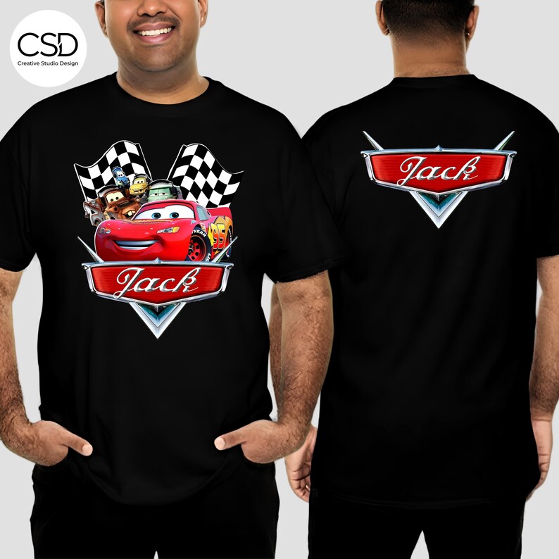 Puede incluir: Camiseta negra con un dise&ntilde;o de coche de carreras rojo y el nombre "Jack". El dise&ntilde;o incluye banderas a cuadros y coches de dibujos animados. La parte trasera de la camiseta tambi&eacute;n tiene el nombre "Jack" en un dise&ntilde;o similar.