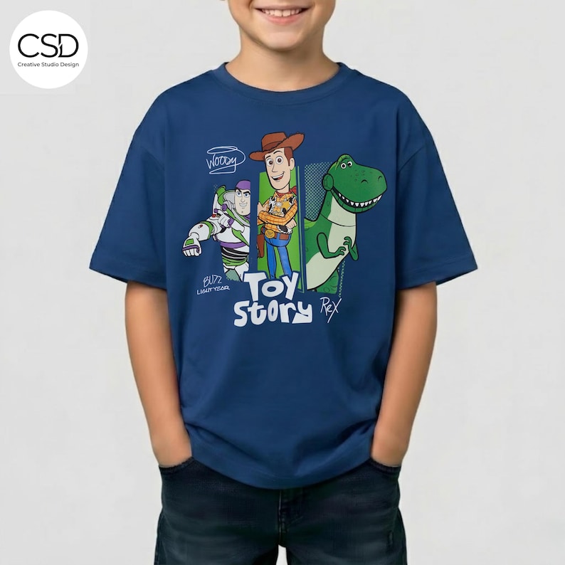 Puede incluir: Una camiseta azul marino con personajes de la pel&iacute;cula de animaci&oacute;n "Toy Story". El dise&ntilde;o incluye a Woody, Buzz Lightyear y Rex el dinosaurio, con las palabras "Toy Story" en una fuente l&uacute;dica. La camiseta la lleva una persona.