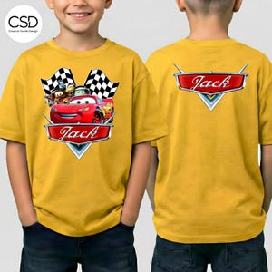 Puede incluir: Camiseta amarilla mostaza con un gr&aacute;fico del personaje Rayo McQueen de la pel&iacute;cula Cars, con el nombre "Jack" en rojo. La parte trasera de la camiseta tambi&eacute;n muestra el nombre "Jack" en un emblema rojo. La camiseta tiene mangas cortas.