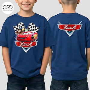 Puede incluir: Camiseta azul marino con un dise&ntilde;o de la pel&iacute;cula Cars, incluyendo a Rayo McQueen, y el nombre "Jack" en una pancarta roja en la parte delantera. La parte trasera de la camiseta tambi&eacute;n muestra el nombre "Jack". La camiseta tiene mangas cortas.