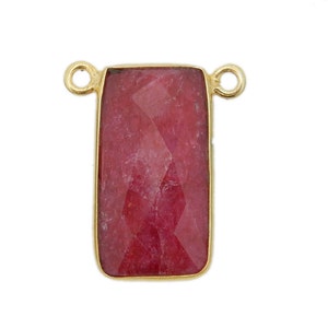 May include: Gold-toned pendant with a rectangular red gemstone. The pendant has two loops on the top for attaching a chain.