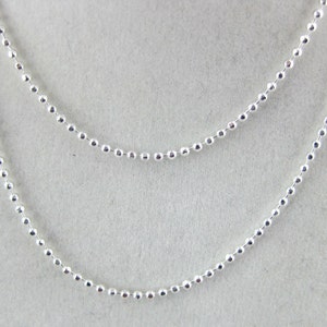 May include: A silver chain necklace with a delicate ball chain design.