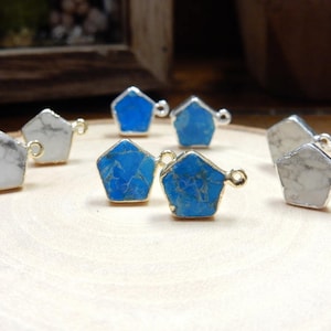 May include: Assortment of turquoise and white gemstone pendants with gold-toned jump rings. The pendants are shaped like irregular pentagons.