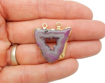 May include: A purple agate pendant with a gold-plated edge and two gold jump rings. The agate has a natural, irregular shape and a heart-shaped opening in the center.