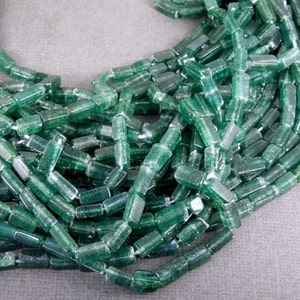 May include: A strand of green glass beads, each bead is a rectangular prism with a slightly frosted finish.
